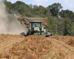 A tractor is driving through the dirt.