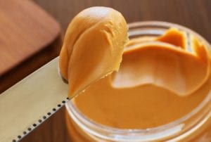 A peanut butter sandwich being cut into pieces.